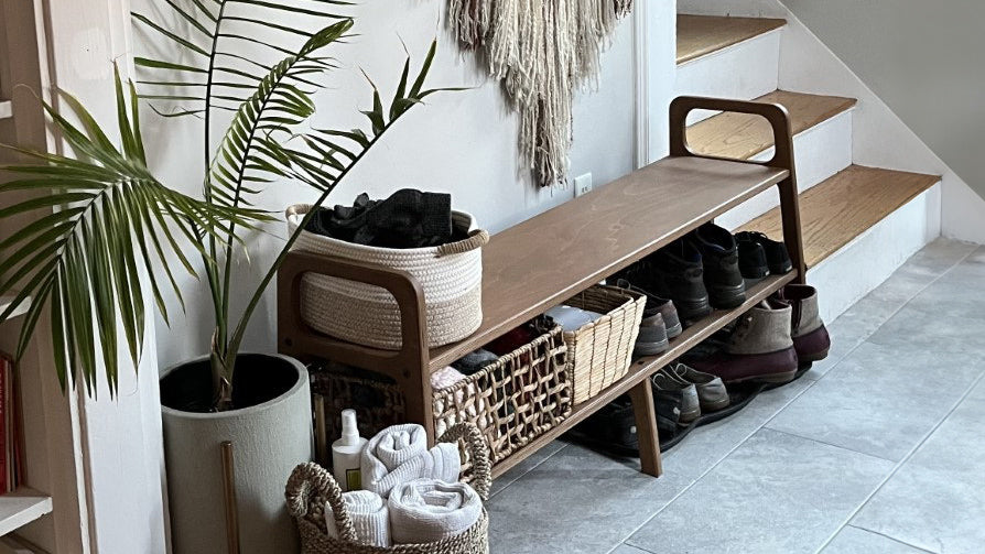 Modern hallway bench in New York apartment with organized shoes and natural decor