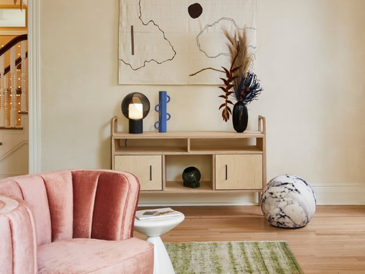 Minimalist plywood sideboard in transparent finish at Dreamers Welcome Hotel in Wilmington, North Carolina, styled with sculptural decor and artwork