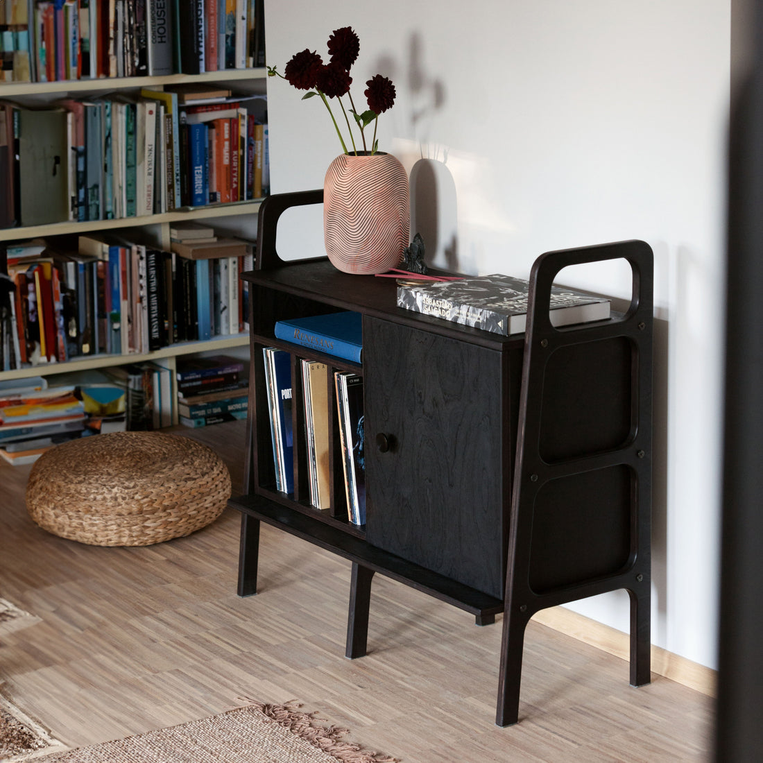 Black-stained plywood vinyl record credenza with turntable, record dividers and cabinet in a mid-century living room