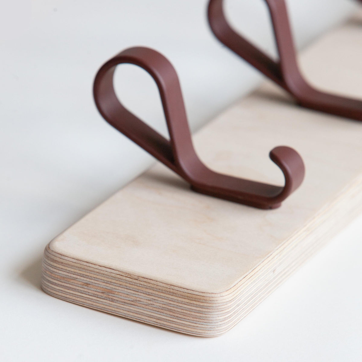 Wall coat rack in birch plywood with metal loop hooks (close-up)