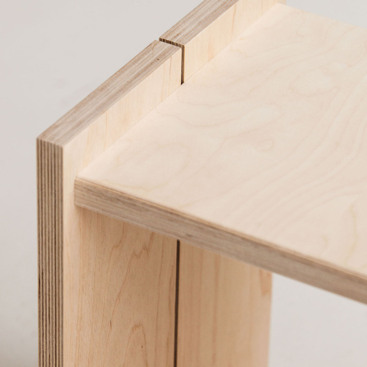 Close-up of a wooden shelf corner with a neutral background
