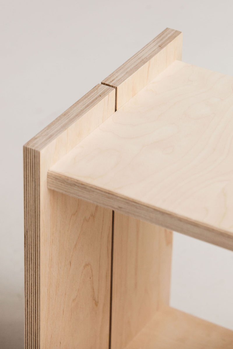Close-up of a wooden shelf corner with a neutral background