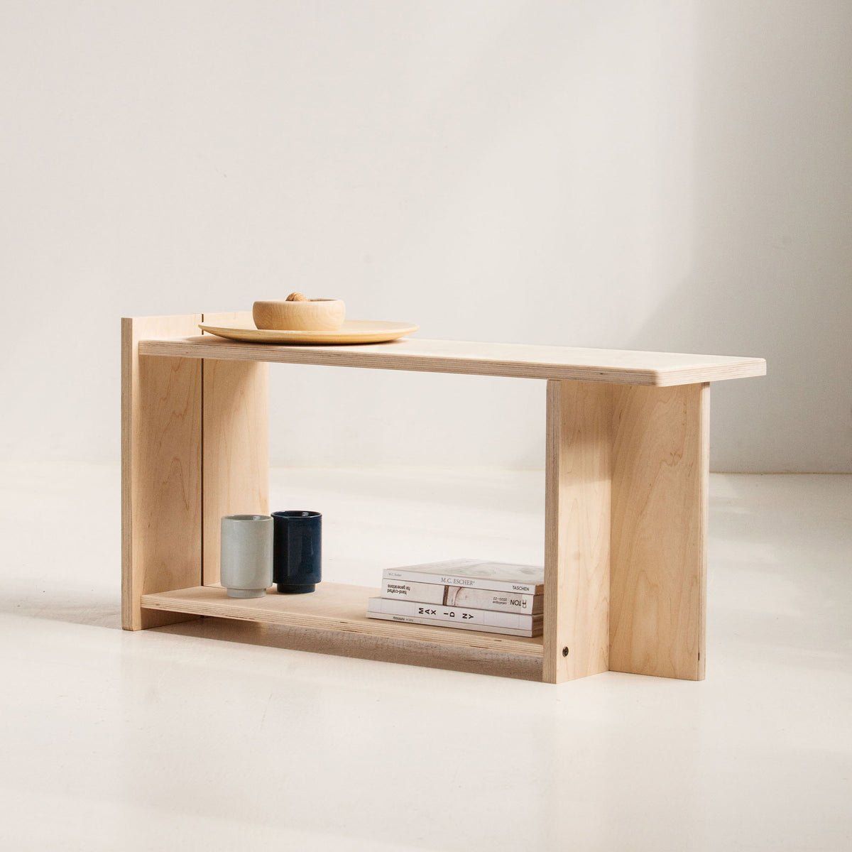 Minimalist wooden shelf with a few items on a plain background