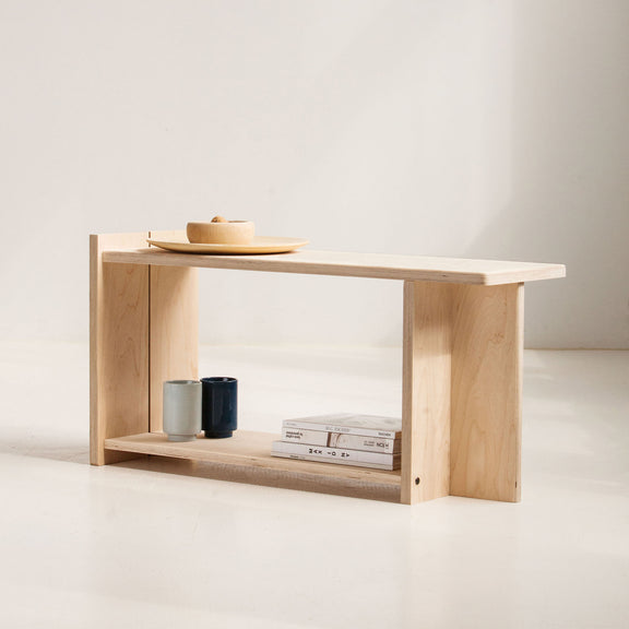 Minimalist wooden shelf with a few items on a plain background