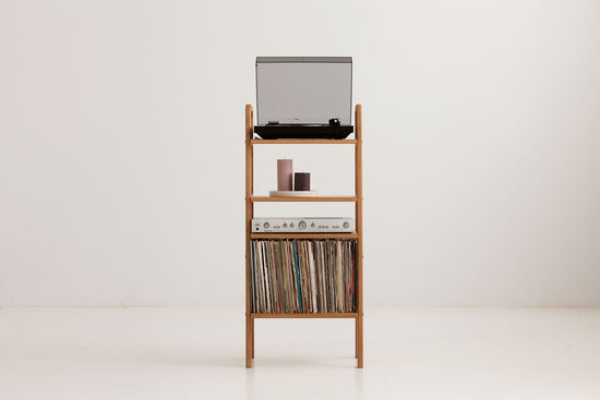 Three-quarter view of the mid-century record player stand showing turntable, display shelf, amplifier shelf and LP storage bay, wooden bookshelf