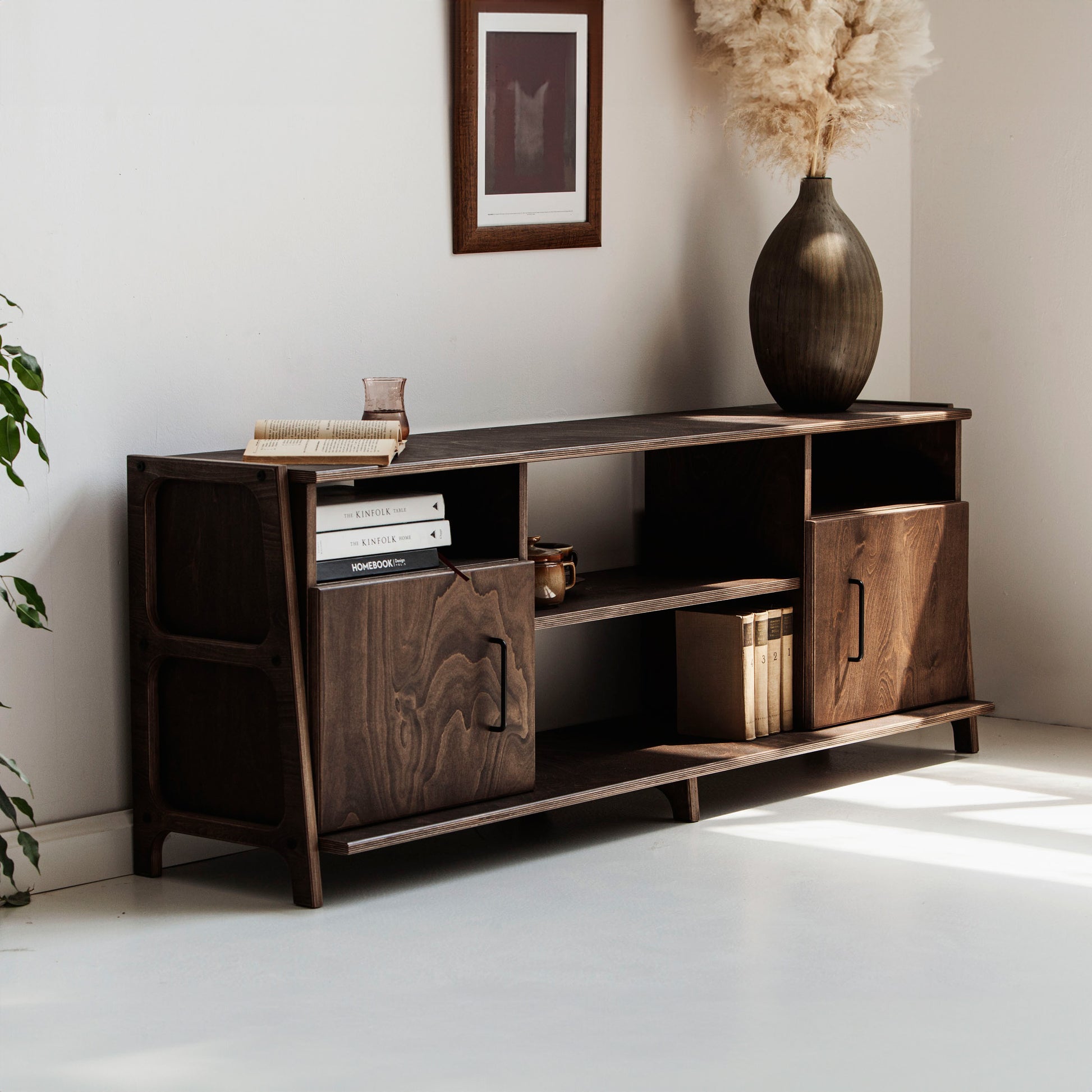 Wooden entertainment console with decorative items in a room setting