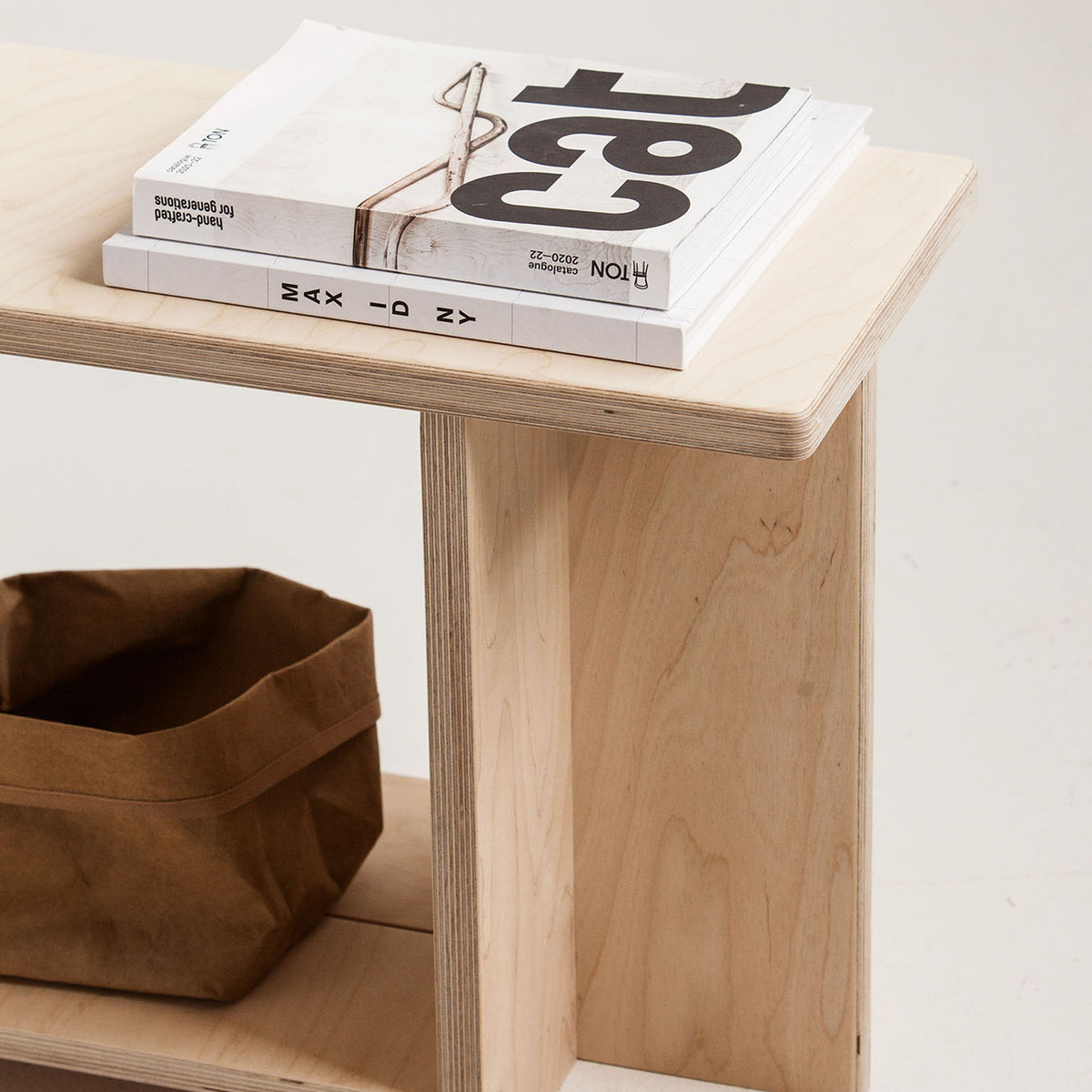 Wooden bench with books and a bag on a light background