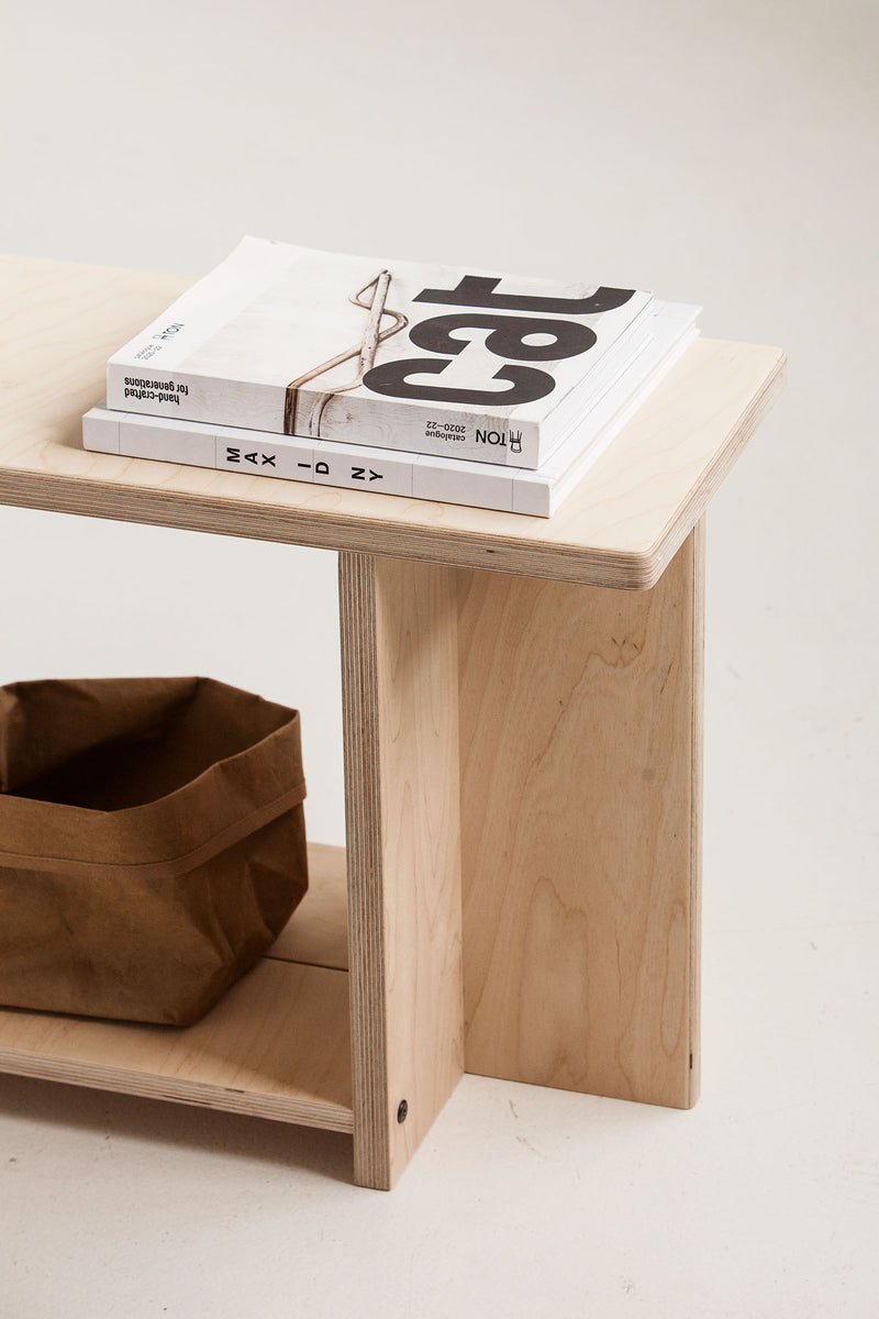 Wooden bench with books and a bag on a light background