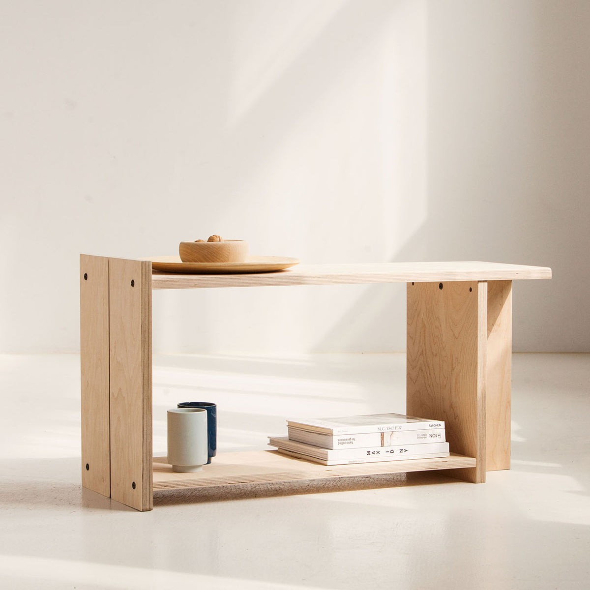 Wooden shelf with books and a bowl on a white background