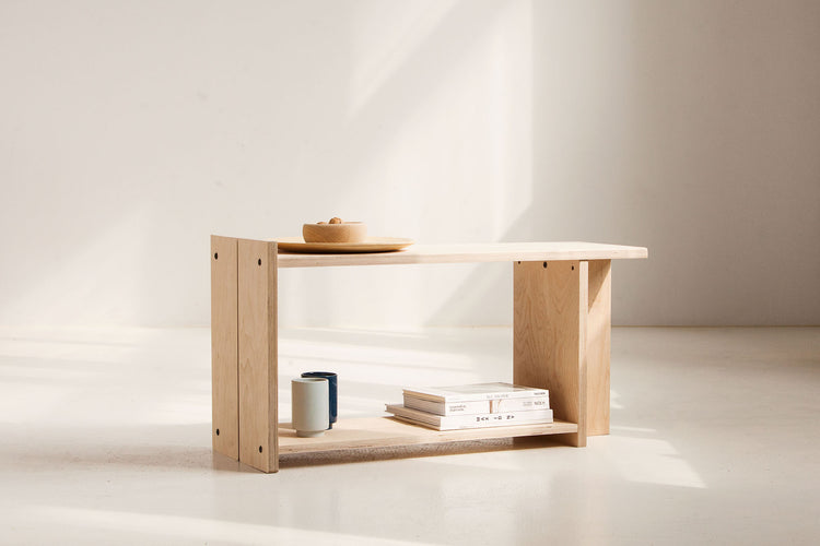 Wooden shelf with books and a bowl on a white background