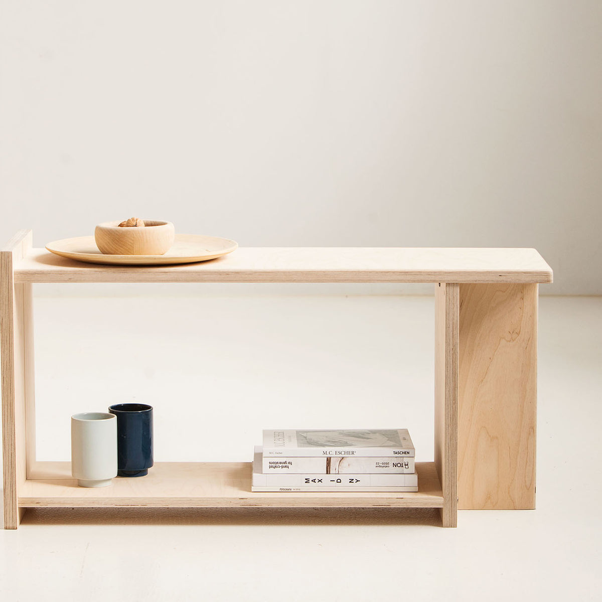 Minimalist wooden shelf with a few items on a plain background