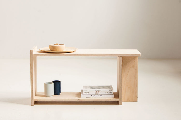 Minimalist wooden shelf with a few items on a plain background