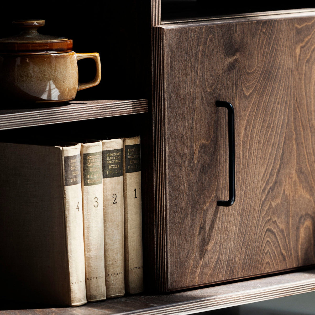 Top view of mid-century wooden TV stand with decorative vase and books